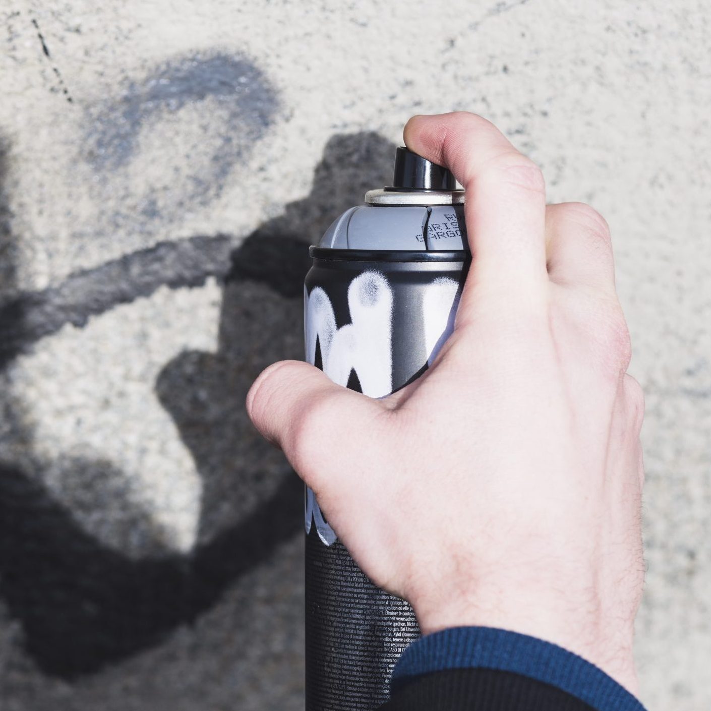 man s hand making graffiti with spray scaled e1705406531148